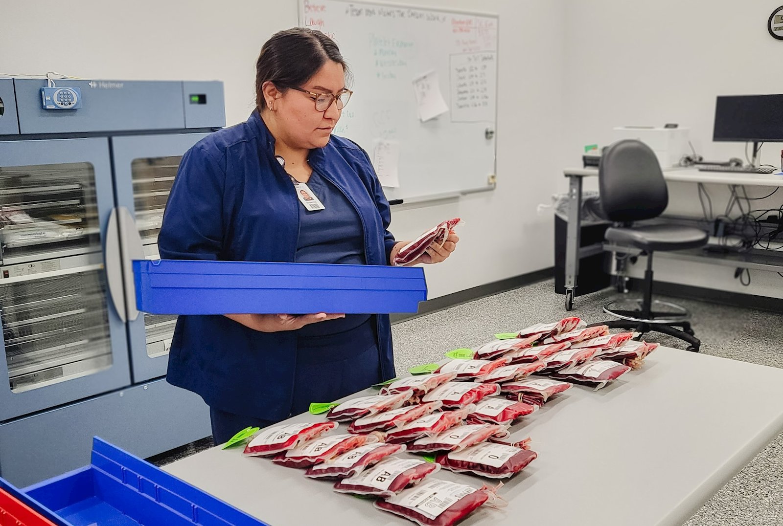 [female in lab processing blood bags 